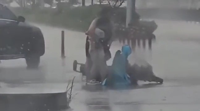 暴雨天，一位母亲载着女儿的电动车侧翻，母亲紧紧抱住受伤的女儿安慰，一位司机冒着雨过去给母女俩撑伞#正能量#感动