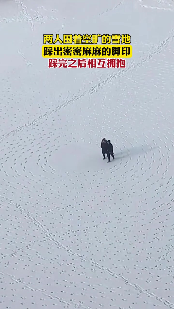 两人围着空旷的雪地踩出密密麻麻整齐的脚印,踩完之后相互拥抱.网友:“你俩不下雪的时候是不是给苏打饼干扎眼的.”