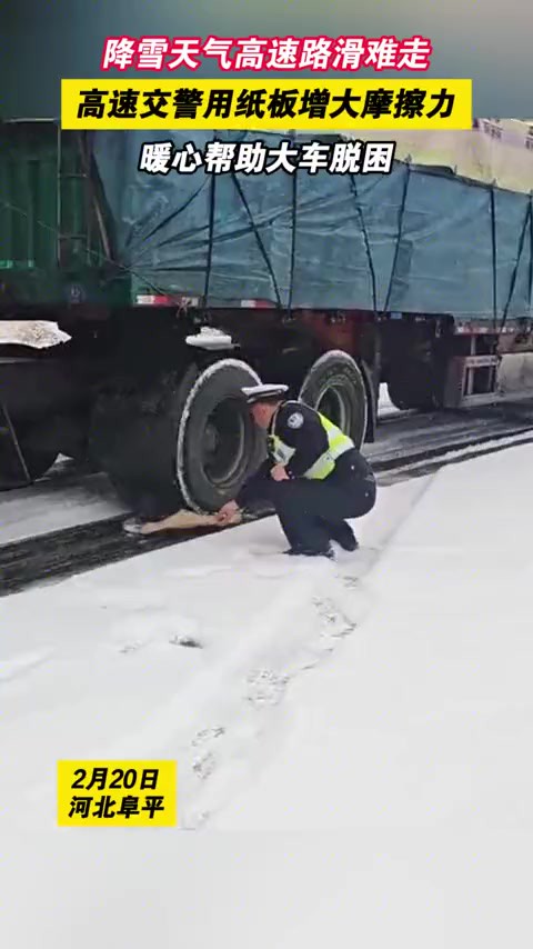 2月20日,河北阜平.降雪天气高速路滑难走,高速交警用纸板增大摩擦力,暖心帮助大车脱困