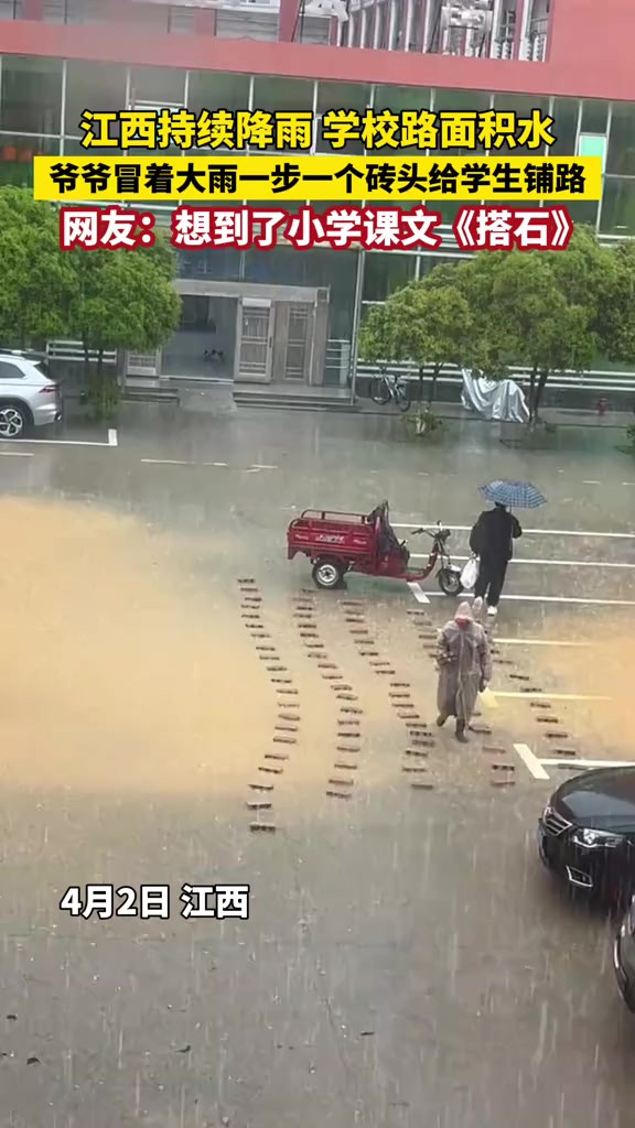 江西持续降雨学校路面积水,爷爷冒着大雨一步一个砖头给学生铺路.网友:想到了小学课文《搭石》.