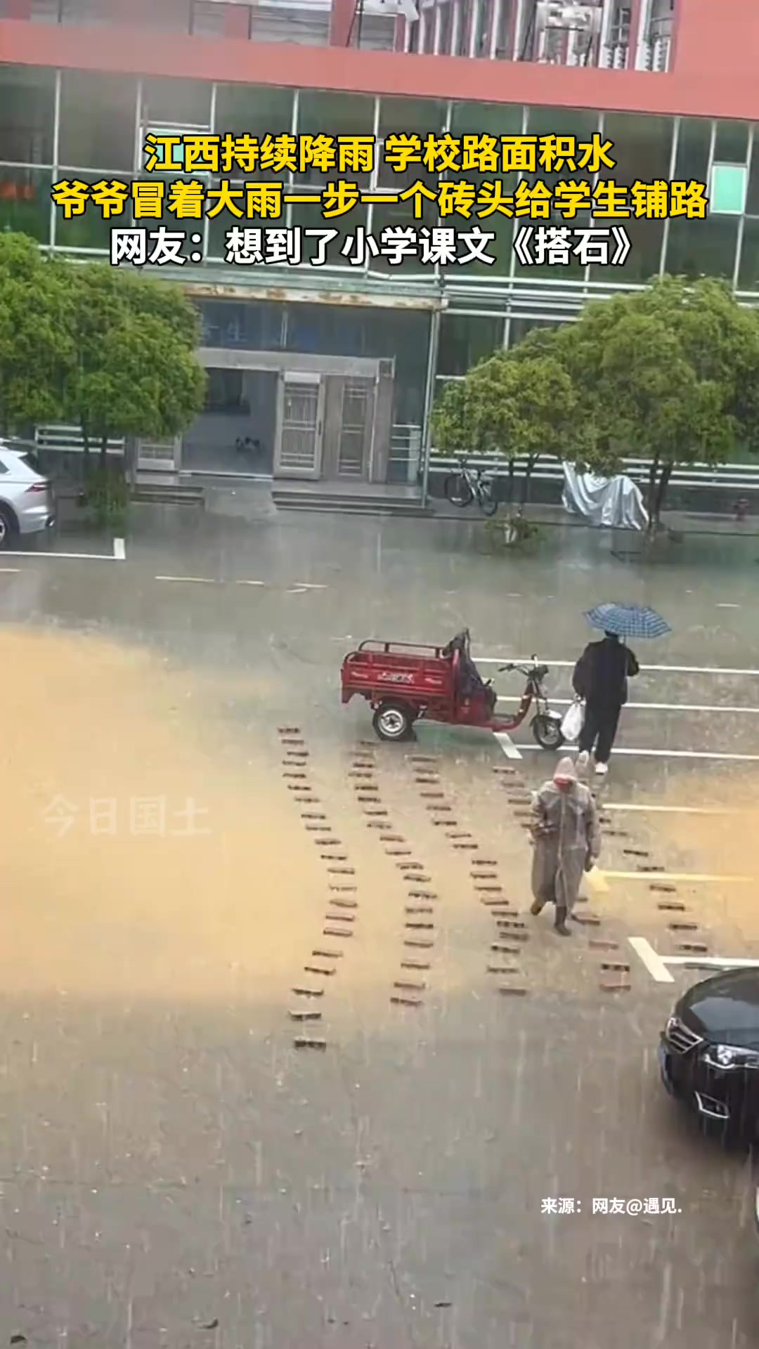 4月2日,江西,江西持续降雨 学校路面积水,爷爷冒着大雨一步一个砖头给学生铺路.网友:想到了小学课文《搭石》.