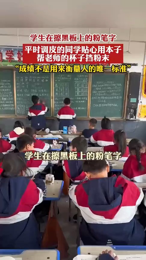 学生在擦黑板上的粉笔字,平时调皮的同学贴心用本子帮老师的杯子